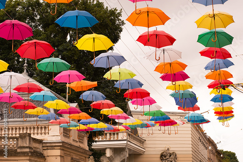 Multi-colored umbrellas background. Colorful umbrellas floating above the street. Street decoration. photo