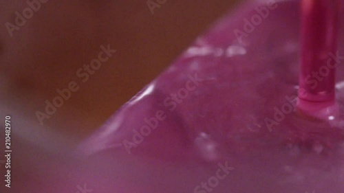 Pouring pink cocktail into a glas with ice (Red.Cinema) (Slowmo)