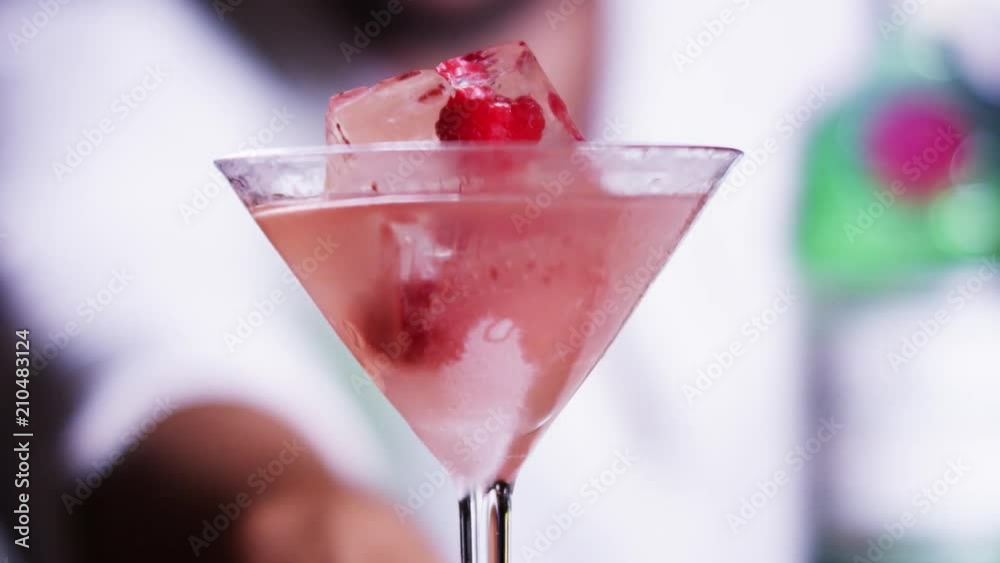 Pouring pink cocktail into a glas with ice (Red.Cinema) (Slowmo)