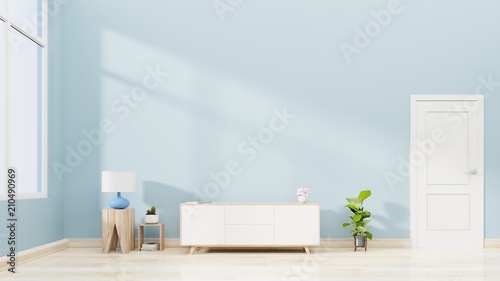 Tv cabinet in modern empty living room with lamp , table , wood floor and blue color wall ,3d rendering
