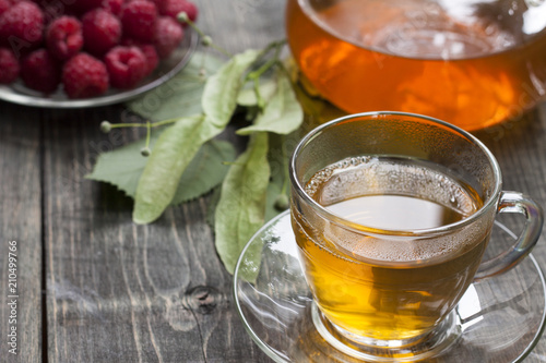 Raspberry and green tea from a linden on a wooden table