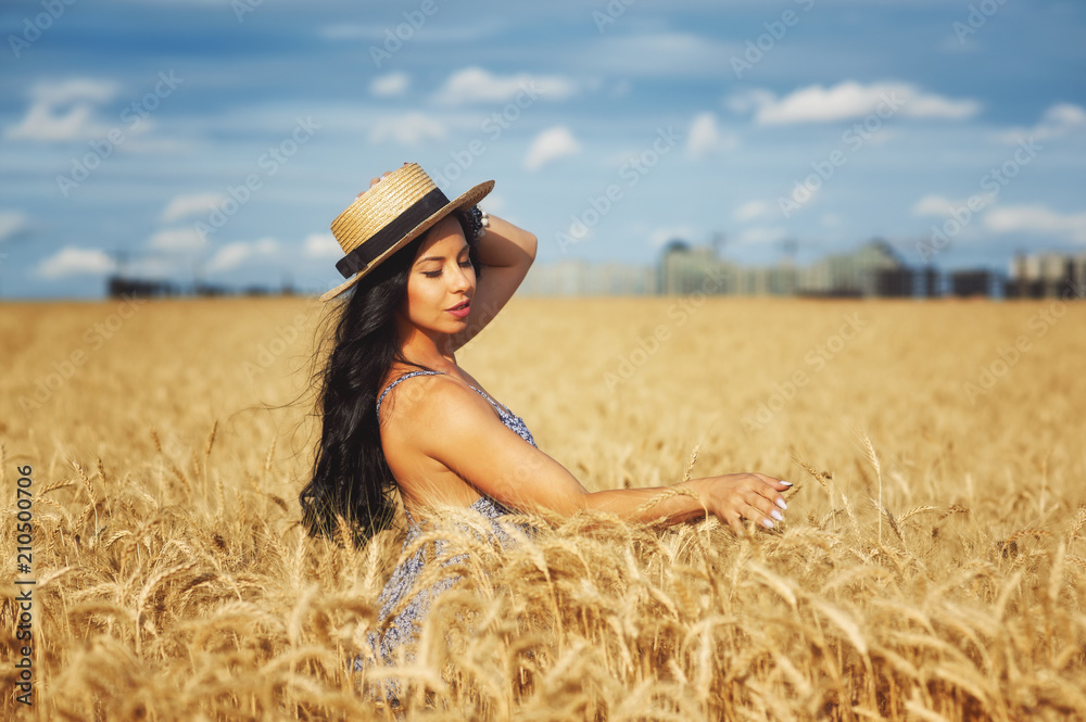 Young romantic woman in light summer dress on a walk in the wheat field Young romantic woman in light summer dress on a walk in the wheat field