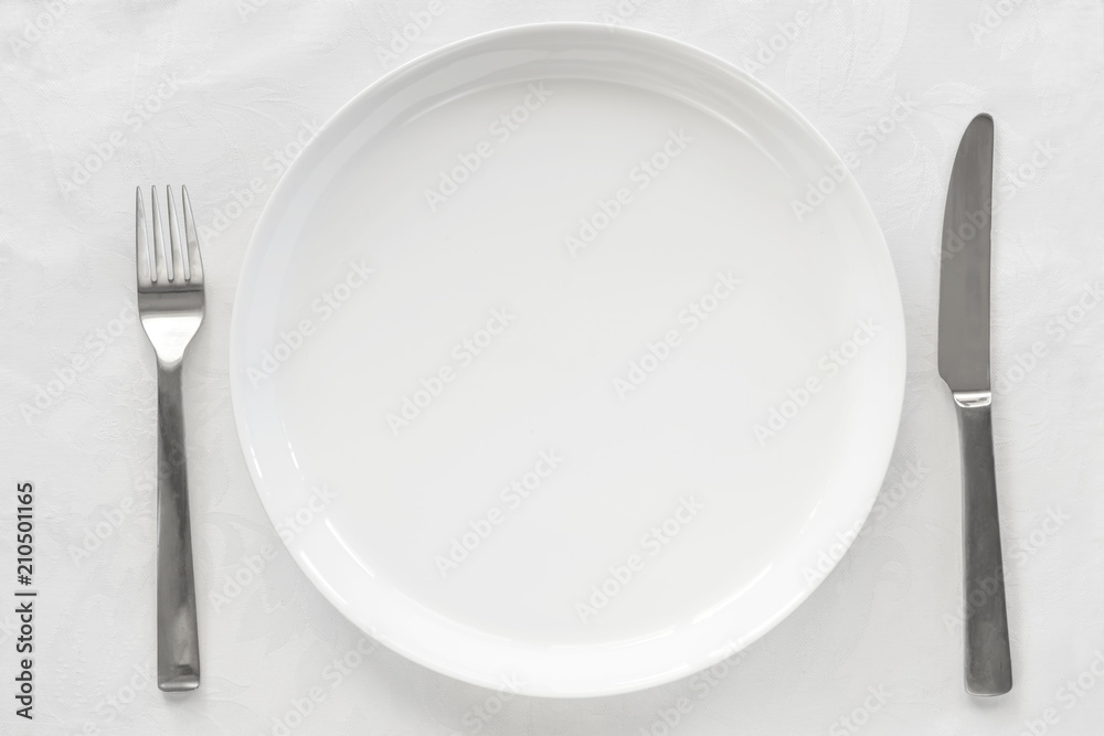 Empty White Plate on Brocade with Knife and Fork Top View Empty White Plate on Brocade with Knife and Fork Top View