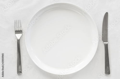 Empty White Plate on Brocade with Knife and Fork Top View