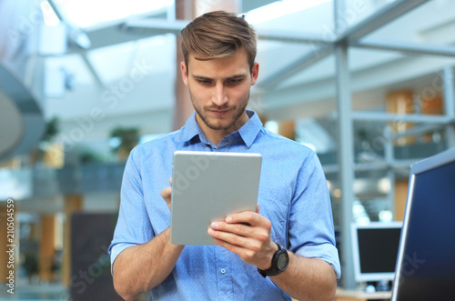 Young man using his tablet in the office.