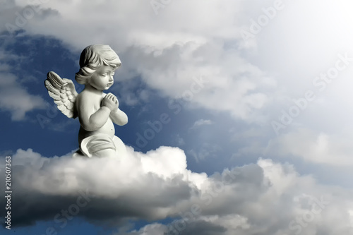 Fotografie Guardian angel kneeling and praying. Angel guardian on the cloud