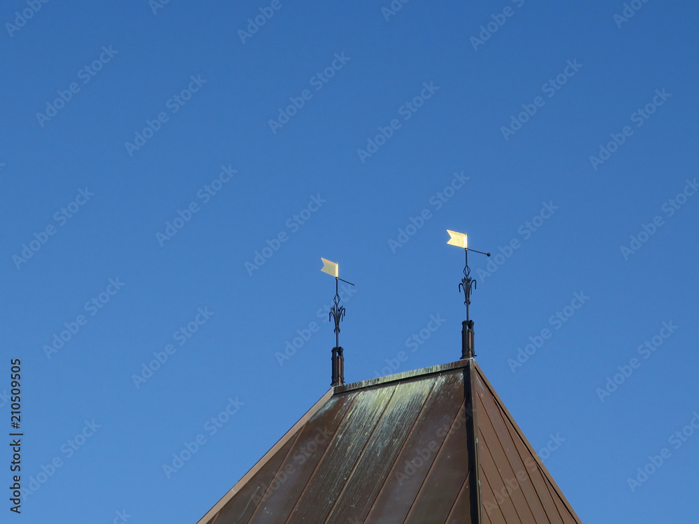 two golden flags on top of a roof two golden flags on top of a roof