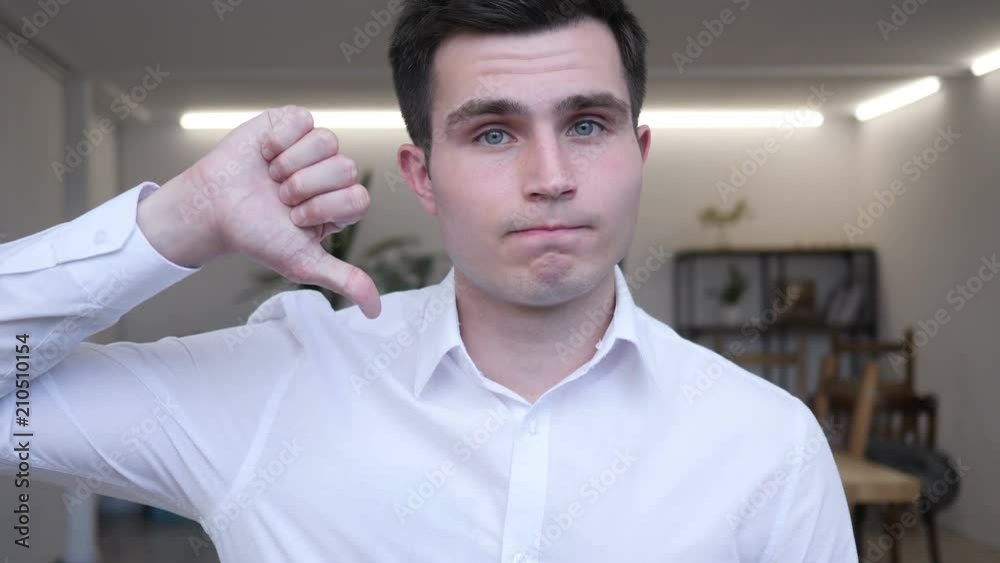 Thumbs Down by Businessman at Work, Looking at Camera Thumbs Down by Businessman at Work, Looking at Camera