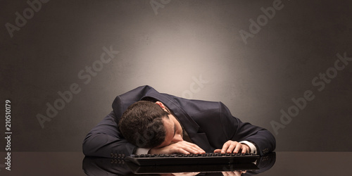 Young businessman fell asleep at his workplace with copy space