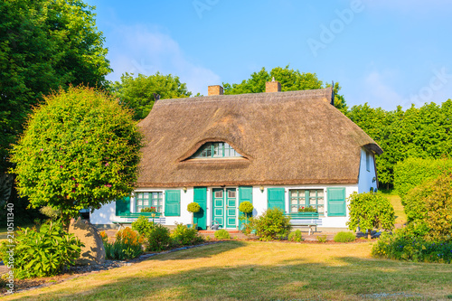 Traditional house with straw roof in and sunny blue sky near Ostseebad Sellin, Ruegen island, Baltic Sea, Germany