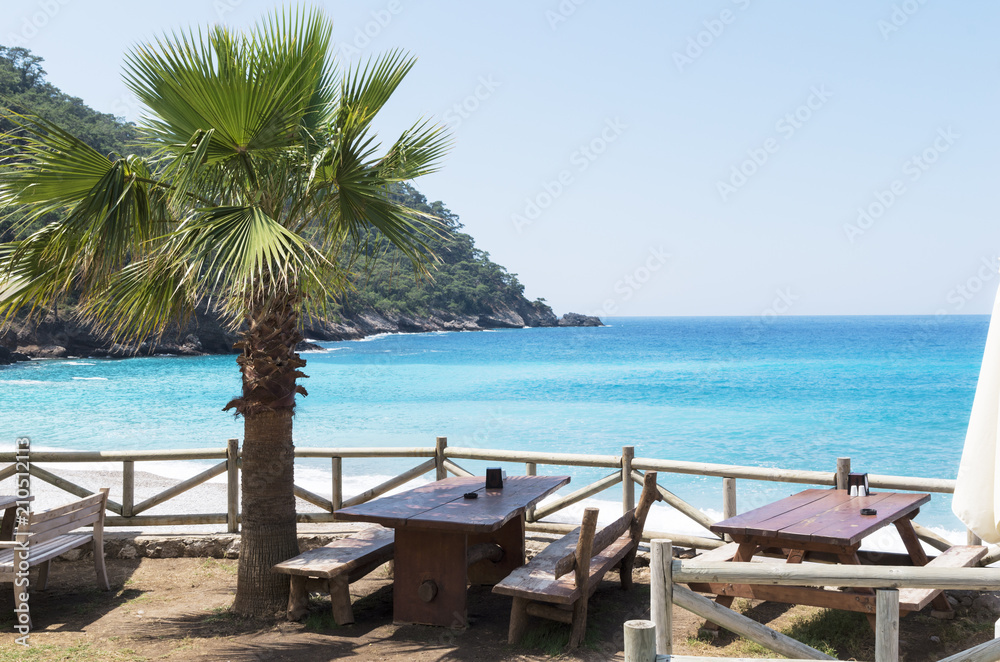 Summer open cafe on the sandy beach of the Mediterranean Sea; The concept of summer holidays or vacation on the seacoast