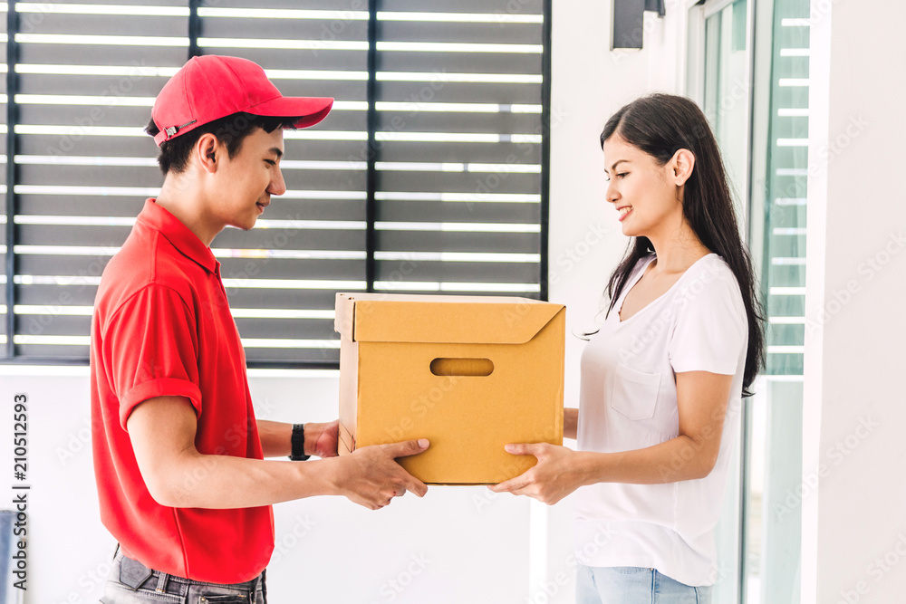 Woman accepting a delivery boxes from delivery man in red uniform.courier service concept