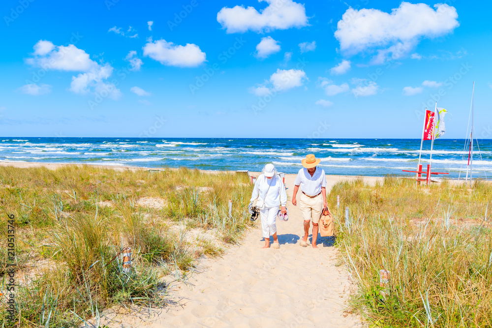 BAABE, RUEGEN ISLAND - MAY 31, 2018: Couple of people walking from beach in Baabe summer resort among sand dunes, Baltic Sea, Germany. Ruegen is popular tourist destination due to its sandy beaches.