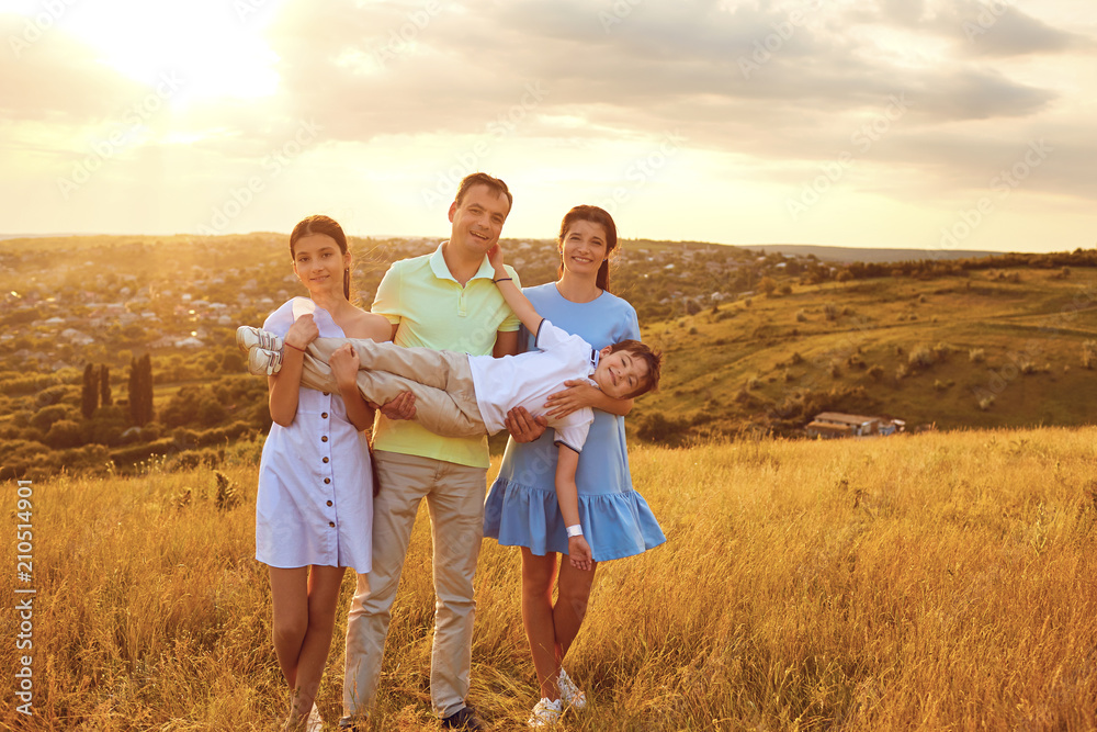Portrait of a happy family sitting on nature in the grass in summer. Portrait of a happy family sitting on nature in the grass in summer.