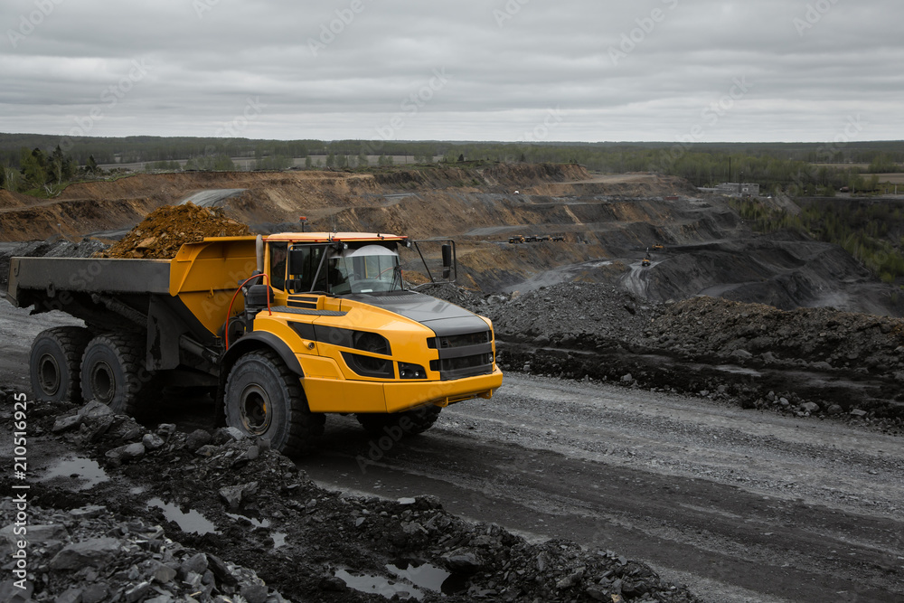 Obraz premium Articulated dump truck on the road in an open coal mine.