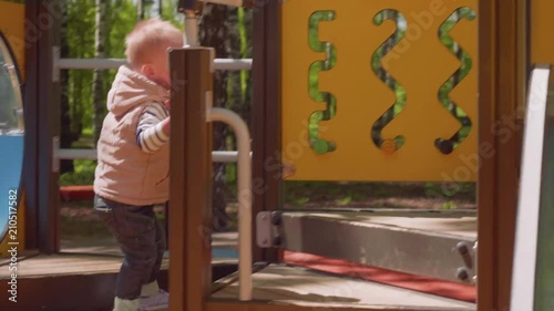 Little blond boy plays on playgournd photo