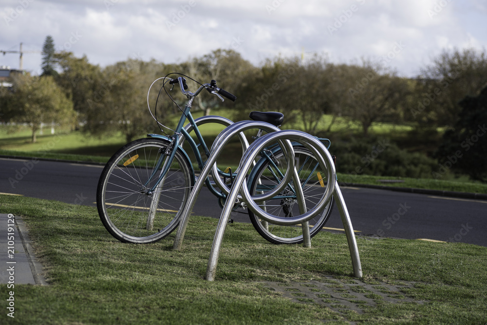 Bicycle locked to a bike rack in the Domain, Auckland, New Zealand. Bicycle locked to a bike rack in the Domain, Auckland, New Zealand.