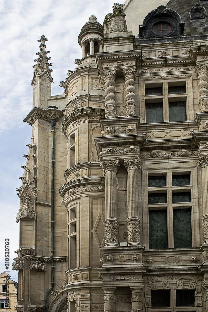A part of a facade with the windows and columns of the town hall in the French city Arras 
