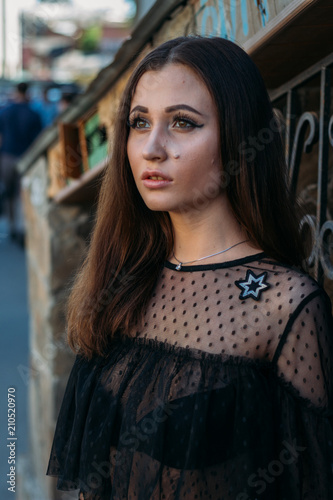 Emotional portrait of Fashion stylish portrait of pretty young woman. city portrait. sad girl. brunette in a black dress. expectation. dreams