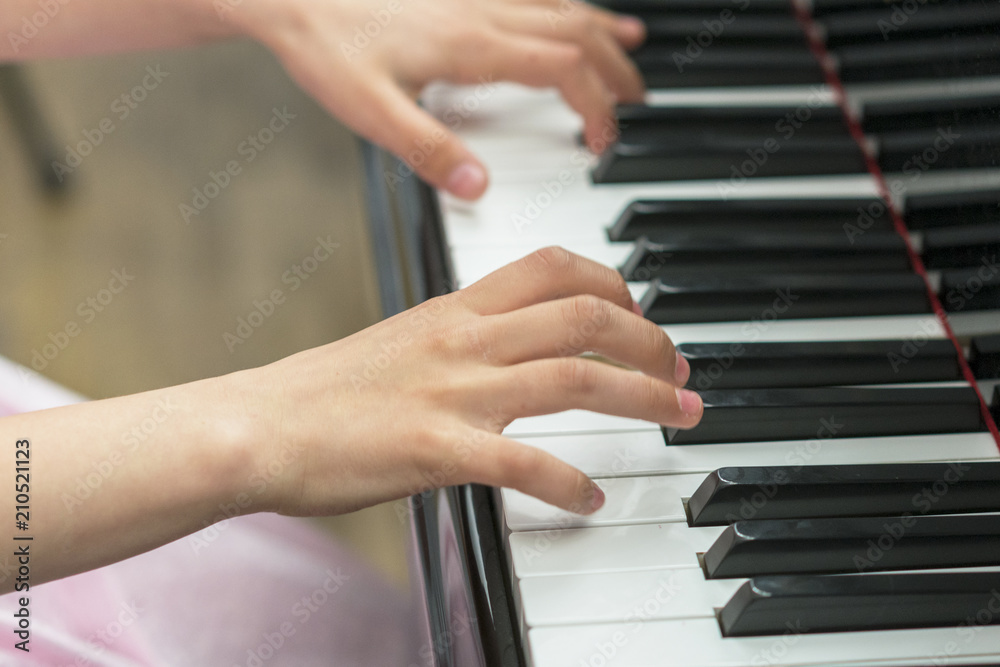 Fototapeta premium children's hands are playing the piano. Child's hand on piano keys.