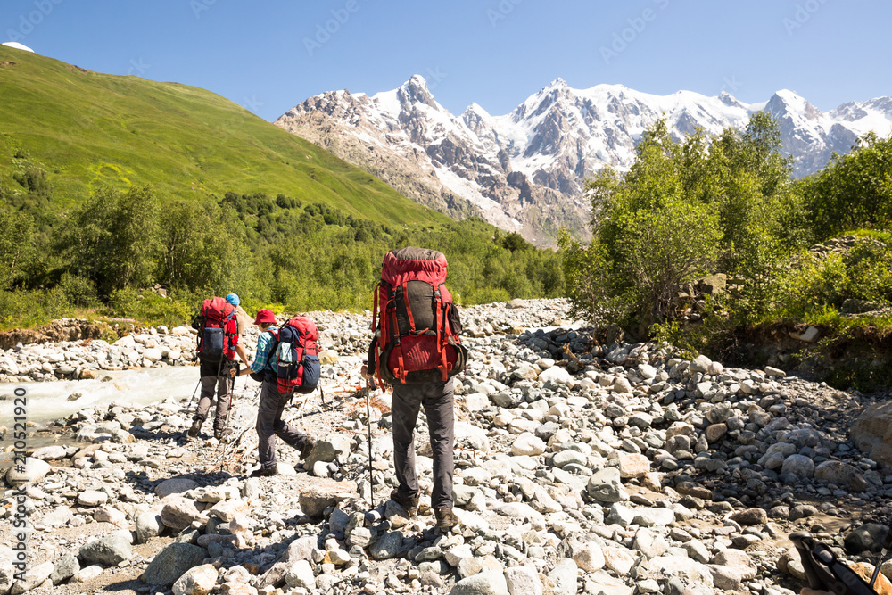 Hiking in beautiful mountains. Group of hikers enjoy sunny weather