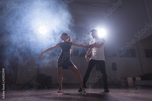 Young couple dancing latin dance Bachata, merengue, salsa. Two elegance pose in dance class © satura_