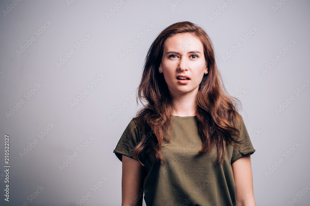 Young woman stands expressing doubt and uncertainty Young woman stands expressing doubt and uncertainty
