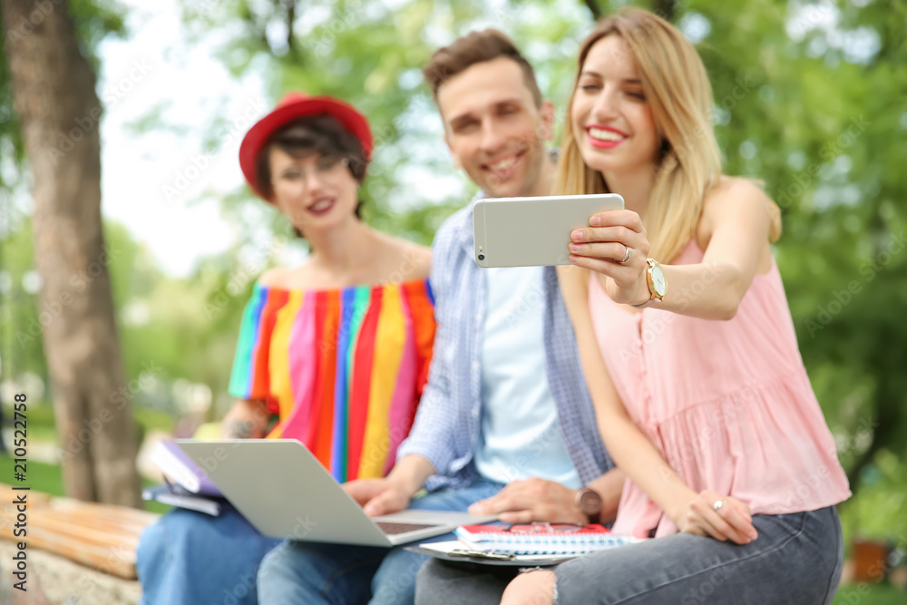 Group of friends in stylish clothes taking selfie outdoors Group of friends in stylish clothes taking selfie outdoors
