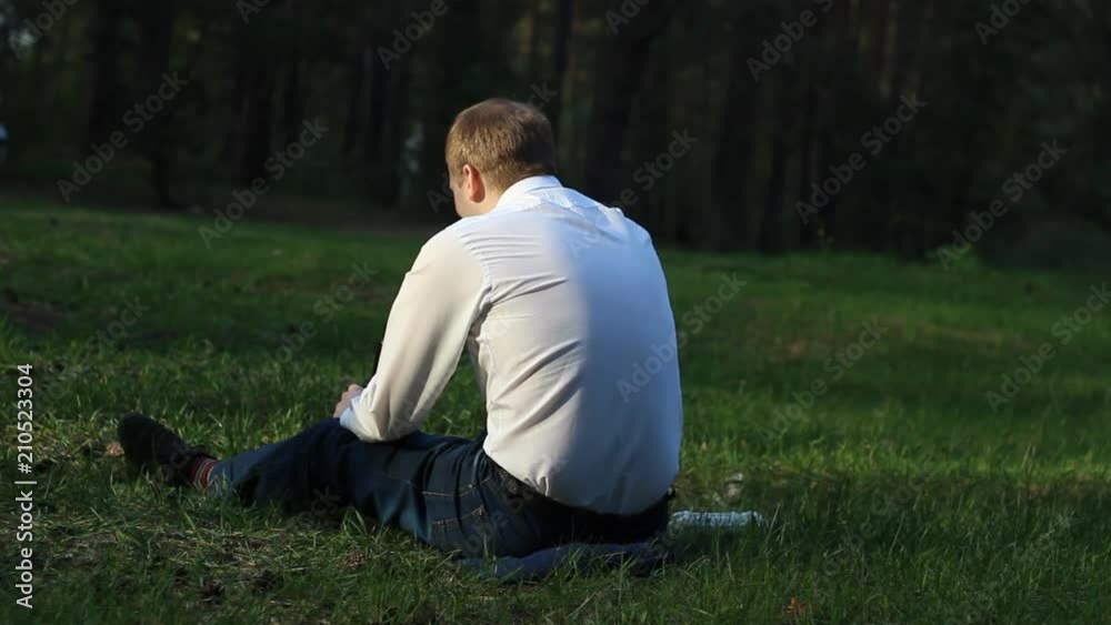 A man on the nature talking on the phone and throwing out a plastic bottle, littering in the open air A man on the nature talking on the phone and throwing out a plastic bottle, littering in the open air