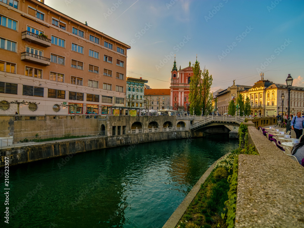 Romantic Ljubljana's city center: river Ljubljanica, Triple Bridge (Tromostovje), Preseren square and Franciscan Church of the Annunciation; Ljubljana, Slovenia, Europe.