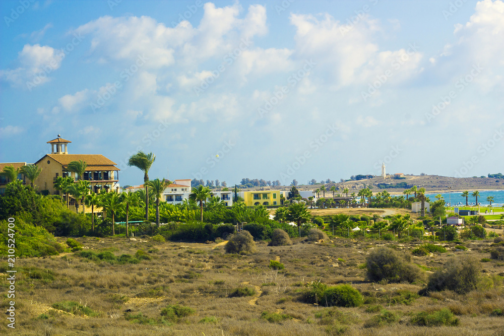 Landscape of town Paphos with houses, trees and lighthouse in background against blue sky, Cyprus Landscape of town Paphos with houses, trees and lighthouse in background against blue sky, Cyprus