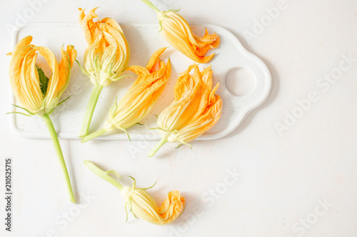 Zucchini flowers on a white board photo