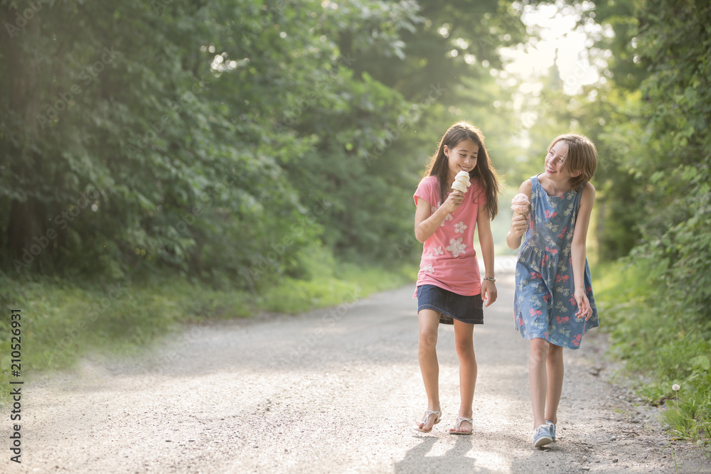 Two happy girls with ice cream cones on a perfect summer day Two happy girls with ice cream cones on a perfect summer day