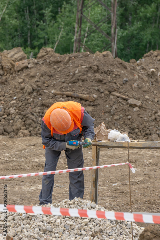 The worker at the construction site makes the formwork The worker at the construction site makes the formwork