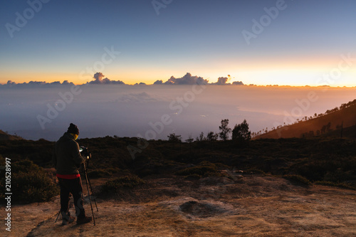 Photographer taking photography sunrise landscape on the mountain in the dawn