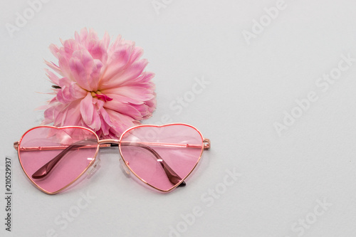 rose-colored glasses and a pink peony bud. concept summer