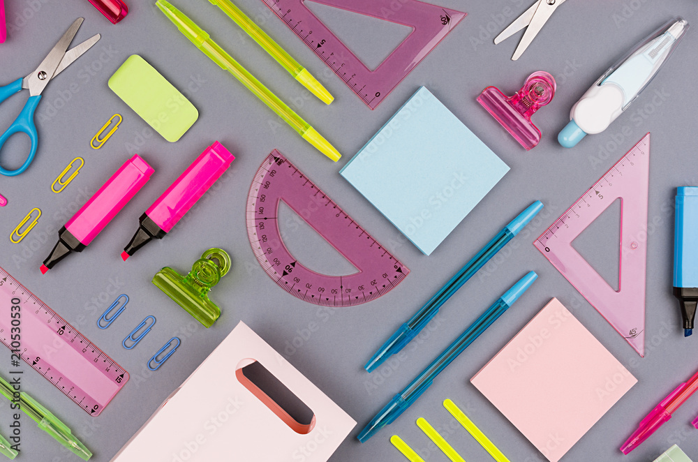 Neon multicolor stationery set as art pattern on grey background, flat lay. Neon multicolor stationery set as art pattern on grey background, flat lay.