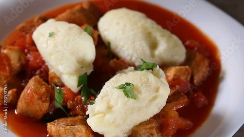 Spreading chopped fresh parsley over Traditional Hungarian food: Goulash with dumplings