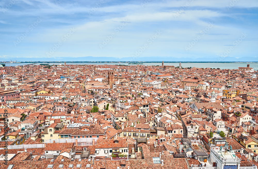 View over Venice and its different quarters / Architecture, rooftops and houses of Venice in Italy seen from St. Mark's Tower