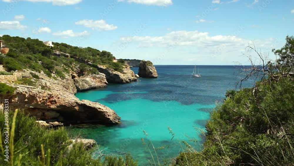 Beautiful view of sailboat and natural rock arch Es Pontas at the coast of Mallorca Santanyi, Spain Mediterranean Sea Beautiful view of sailboat and natural rock arch Es Pontas at the coast of Mallorca Santanyi, Spain Mediterranean Sea