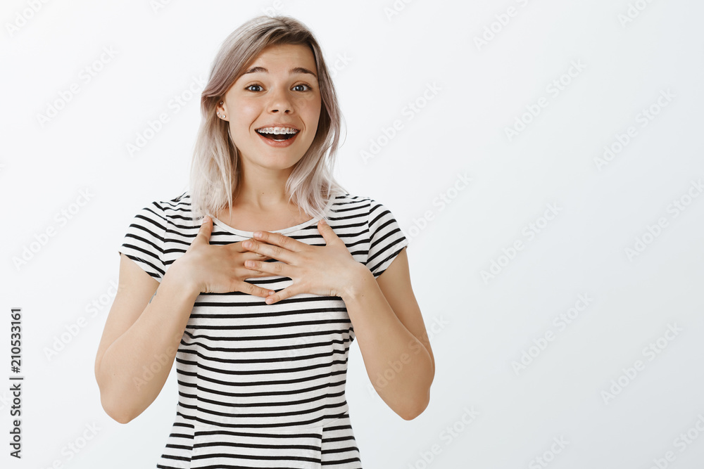 Oh my heart melts from such warm words. Portrait of passionate pleased cute woman with fair hair, holding palms on chest and smiling joyfully, being surprised receiving cute compliment Oh my heart melts from such warm words. Portrait of passionate pleased cute woman with fair hair, holding palms on chest and smiling joyfully, being surprised receiving cute compliment