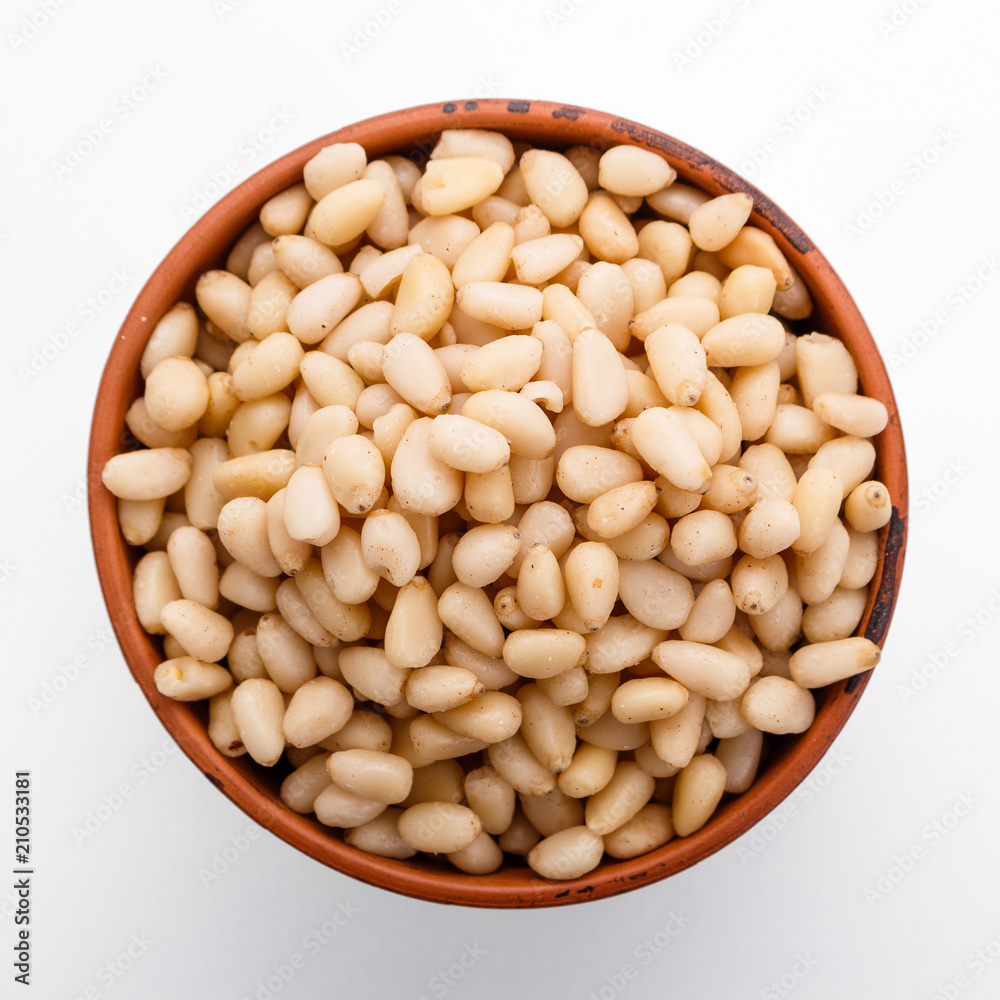 peeled pine nuts on a white acrylic background peeled pine nuts on a white acrylic background