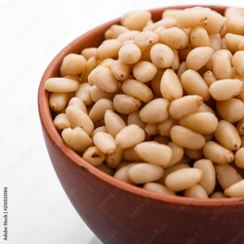 peeled pine nuts on a white acrylic background peeled pine nuts on a white acrylic background