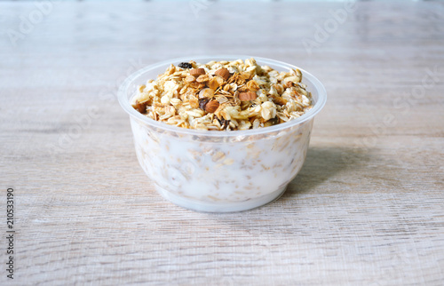close up  muesli in bowl with milk or yogurt on wooden background, granola healthy meal, food organic concept