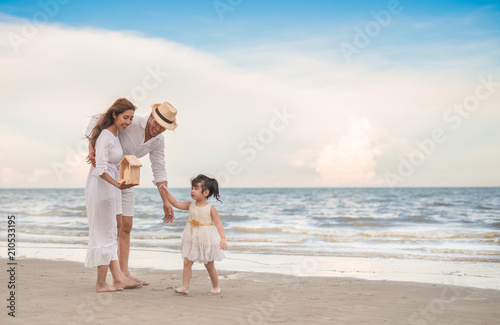 parent's hands and daughter holding private property in sea beach