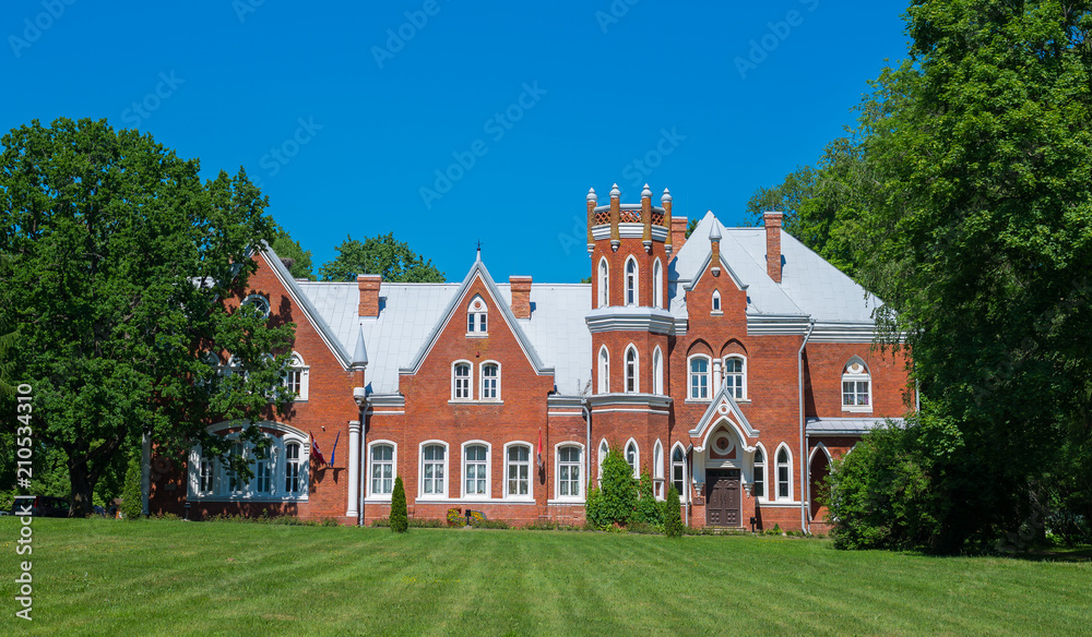 Ancient castle from red bricks with green garden