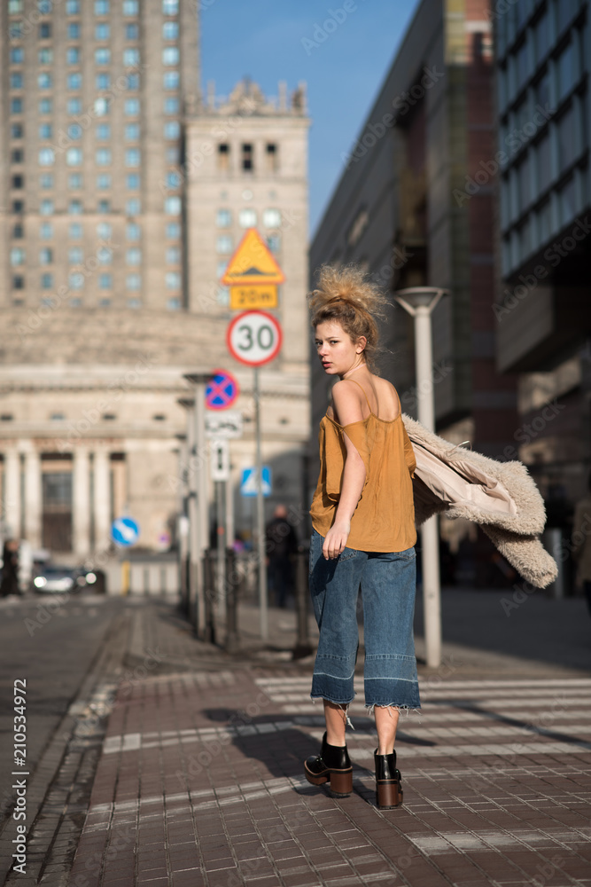 beautiful girl walking through the city streets