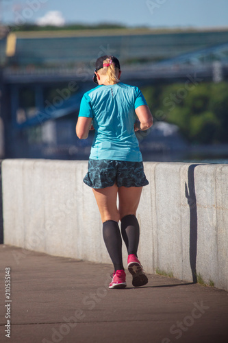 The girl is running on the road in the city