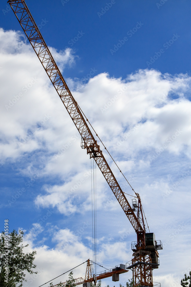 Tower crane on a construction site against the sky
