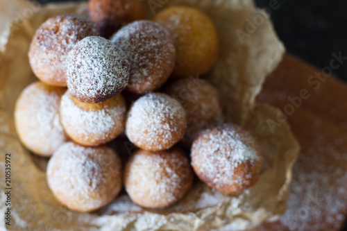 Donuts close-up. Italian fritters - traditional dish on a gray background on a wooden board.